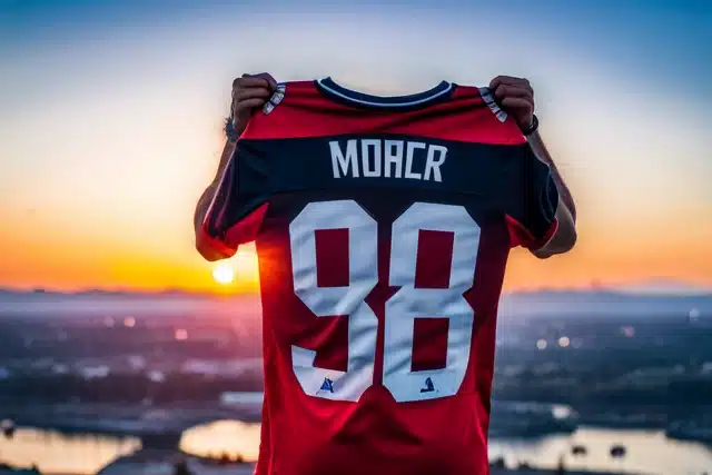 A person holding up an autographed sports jersey